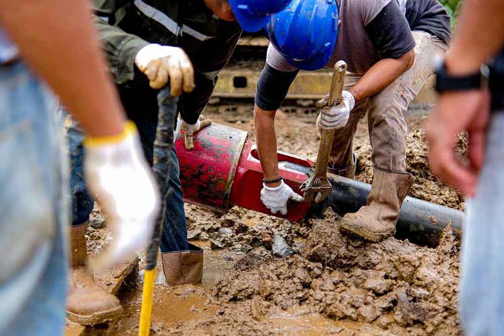 Workers using trenchless equipment to repair pipes
