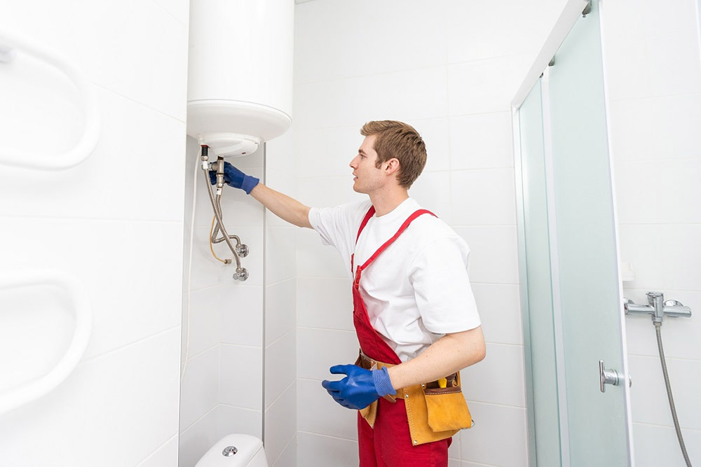 technician inspecting a water heater technician inspecting a water heater